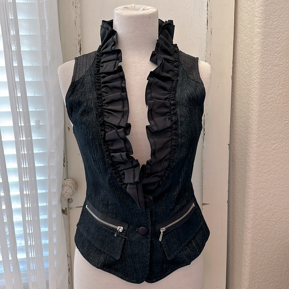 Women’s ruffle vest with zippers and cute button detail on back side.